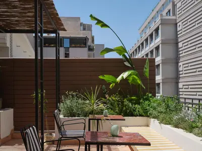 a patio with a table and chairs on a balcony at Astikon House in Athens