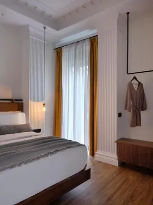 a bedroom with a bed and a large window at Astikon House in Athens