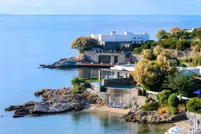 an aerial view of a house on a rocky island in the water at Grand Resort Lagonissi in Lagonissi