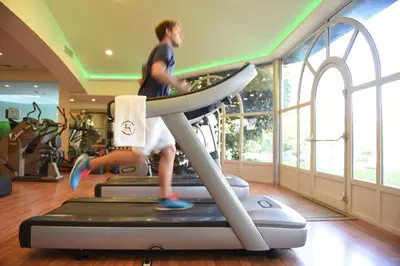 a man running on a treadmill in a gym at Grand Resort Lagonissi in Lagonissi