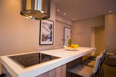 a kitchen with a island with a stove and chairs at Elegant House Under Acropolis in Athens