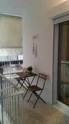 a table and chairs sitting on the side of a building at Elegant House Under Acropolis in Athens