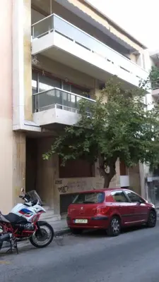 a red car and a motorcycle parked in front of a building at Elegant House Under Acropolis in Athens