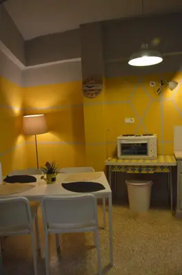 a kitchen with yellow walls and a table and a microwave at Home Sweet Home in Athens