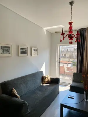 a living room with a blue couch and a chandelier at Art Suites Athens in Athens