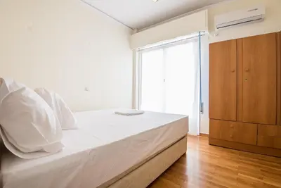 a bedroom with a large white bed and a window at Acropolis View Paradise Apartments in Athens