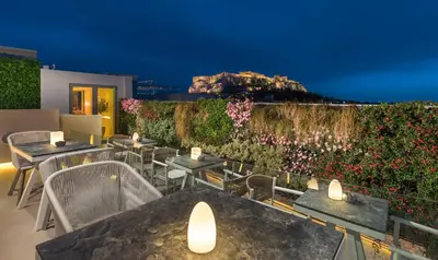 a restaurant with tables and chairs and a wall with flowers at Central Hotel in Athens