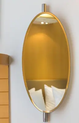 a gold mirror on a wall with white pillows at Central Hotel in Athens