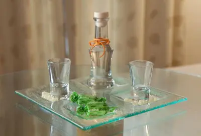 a glass bottle and two glasses on a glass table at Central Hotel in Athens