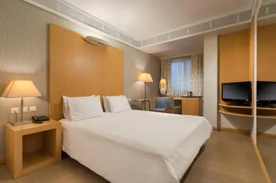 a hotel room with a large bed and a television at Central Hotel in Athens