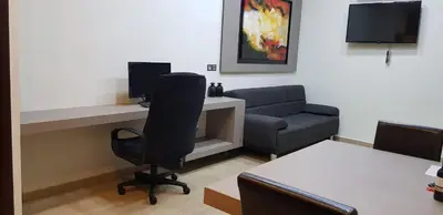 a living room with a couch and a desk and a chair at Minimal Studio in Paleo Faliro in Athens
