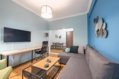 a living room with a couch and a desk at Boutique Acropolis Apartment by Cloudkeys - Just 5 minutes walk to Acropolis Museum in Athens