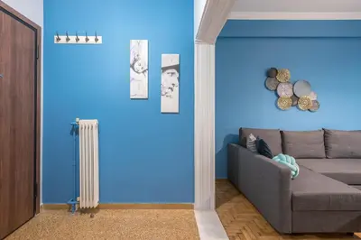 a living room with a couch and a blue wall at Boutique Acropolis Apartment by Cloudkeys - Just 5 minutes walk to Acropolis Museum in Athens