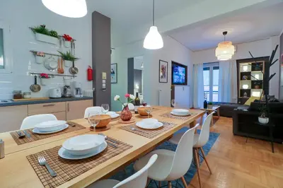 a dining room and living room with a table and chairs at Angels in Athens