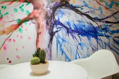a cactus sitting on a table in front of a painting at Angels in Athens