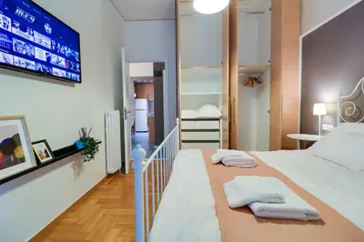 a bedroom with a large bed with towels on it at Angels in Athens