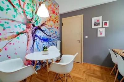 a table and chairs in a room with a painting at Angels in Athens