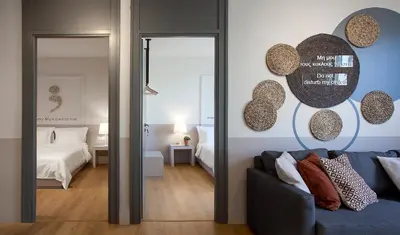 a living room with a blue couch and a bedroom at Great Living Apartments in Athens