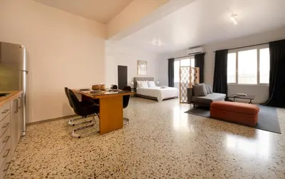 a kitchen and living room with a table and chairs at Studio Pittaki - Large Studio in Athens Historic Center, Near Acropolis in Athens