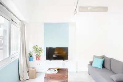 a living room with a couch and a tv at Na'maste Apartments in Athens