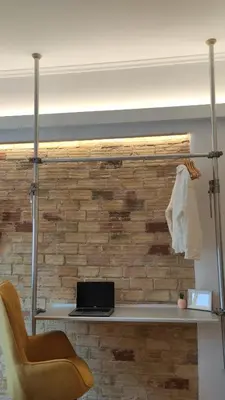 a desk with a laptop on a brick wall at Na'maste Apartments in Athens