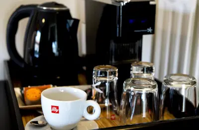 a cup of coffee and glasses on a counter at Athens Edition Guesthouse in Athens