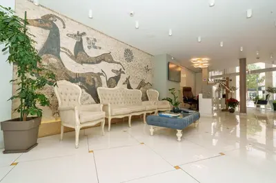a lobby with chairs and a wall with a mural at Acropolian Spirit Boutique Hotel in Athens