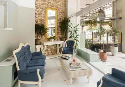 a living room with two blue chairs and a table at Acropolian Spirit Boutique Hotel in Athens