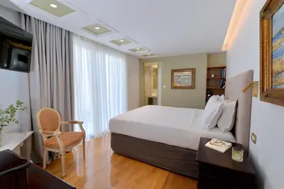 a hotel room with a bed and a desk and a television at Acropolian Spirit Boutique Hotel in Athens