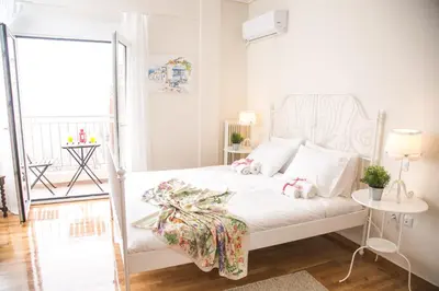 a bedroom with a white bed with a white headboard at Magnificent luxury retrostyle flat Acropolis view in Athens