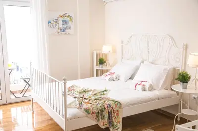 a bedroom with a white bed with a christmas bow on it at Magnificent luxury retrostyle flat Acropolis view in Athens