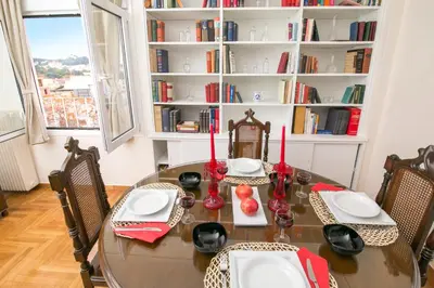 a dining room table with chairs and a book shelf at Magnificent luxury retrostyle flat Acropolis view in Athens