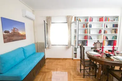 a living room with a blue couch and a table at Magnificent luxury retrostyle flat Acropolis view in Athens