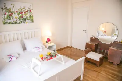 a bedroom with a white bed and a table with drinks on it at Magnificent luxury retrostyle flat Acropolis view in Athens