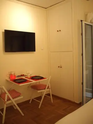 a room with a desk and a television on the wall at Charming Studio Posh Quartier (Kolonaki Athens) in Athens