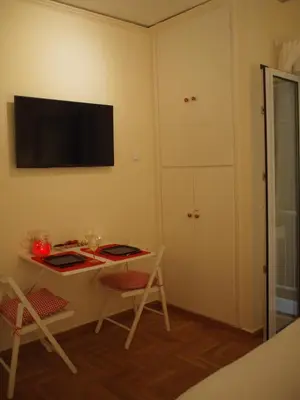 a room with a desk and a tv on the wall at Charming Studio Posh Quartier (Kolonaki Athens) in Athens