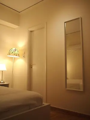 a bedroom with a bed and a mirror and a lamp at Charming Studio Posh Quartier (Kolonaki Athens) in Athens