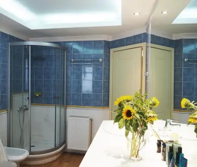 a bathroom with a glass shower and a vase of flowers at Best Point To Stay in Athens