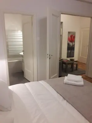 a bedroom with a white bed and a bathroom at Stylish apartment in Kolonaki in Athens