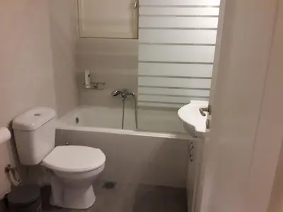a bathroom with a toilet and a tub and a sink at Stylish apartment in Kolonaki in Athens