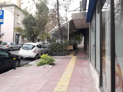 a sidewalk in front of a building with cars parked at Stylish apartment in Kolonaki in Athens