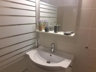 a bathroom with a white sink and a mirror at Stylish apartment in Kolonaki in Athens