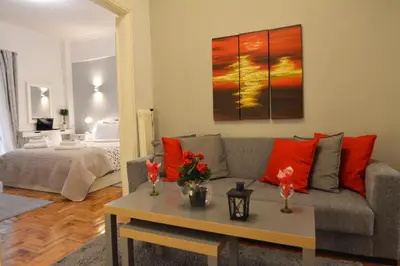 a living room with a couch and a table with red pillows at Stylish apartment in Kolonaki in Athens