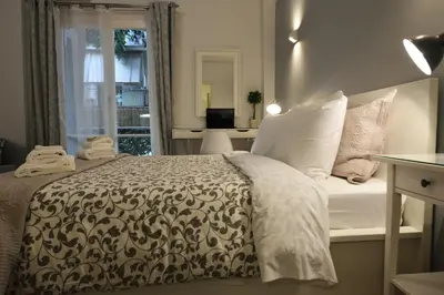a bed with a black and white comforter and a window at Stylish apartment in Kolonaki in Athens