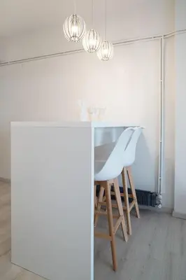 a white kitchen with a table and chairs at Plaka Heart in Athens