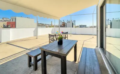a wooden table on the roof of a building at Ceramus Apartments Gazi View in Athens