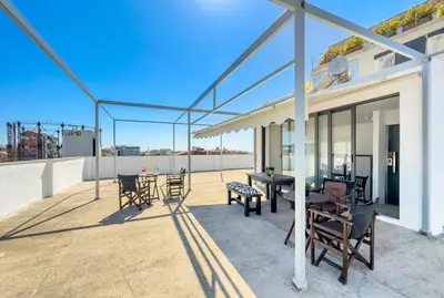 a patio with a table and chairs on a roof at Ceramus Apartments Gazi View in Athens