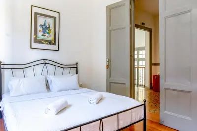 a bedroom with a bed with two towels on it at Dioskouros Hostel in Athens