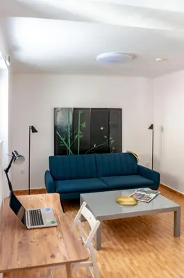 a living room with a blue couch and a table at Dioskouros Hostel in Athens