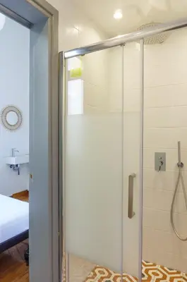 a shower with a glass door in a bathroom at Dioskouros Hostel in Athens